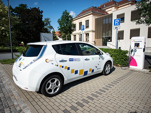 An electric car is parked in the electric parking lot in front of building Z one of the HSZG.