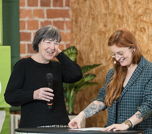 Presenter and studio guest laugh in the live studio.