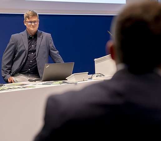 Jonas Pfeiffer stands in front of a laptop and looks into the audience.