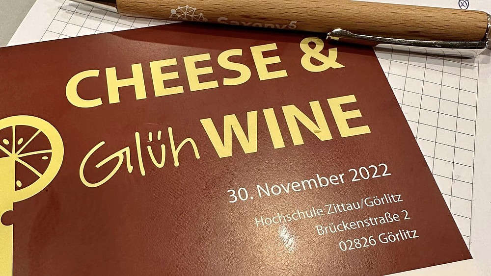 A menu with cheese and mulled wine on it.