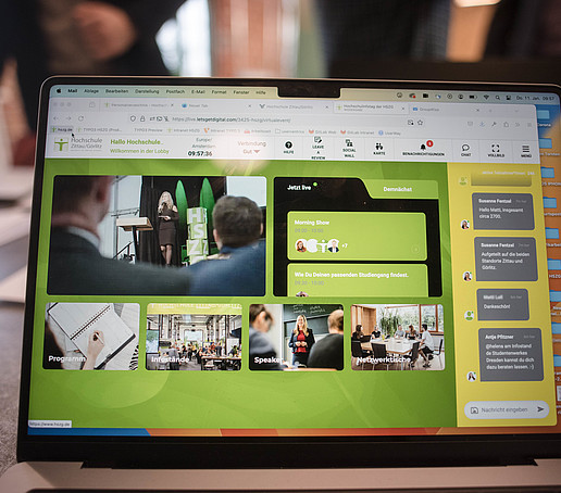 Laptop screen showing the digital platform with various tiles.