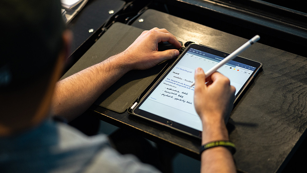 Student schreibt auf einem Tablet