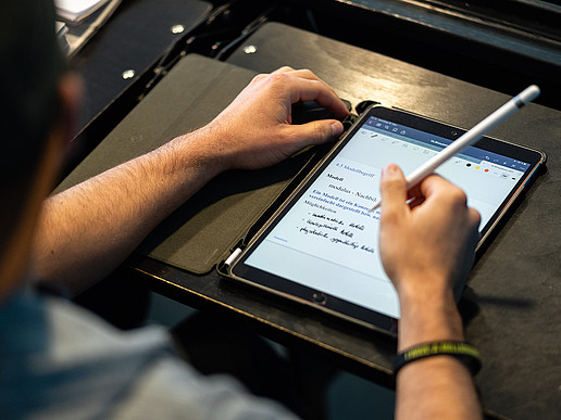 Student writes on a tablet