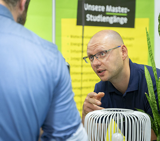 HSZG employee in conversation with a visitor.