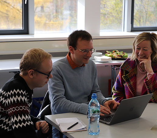 The Vice Rector talks to workshop participants at the table.