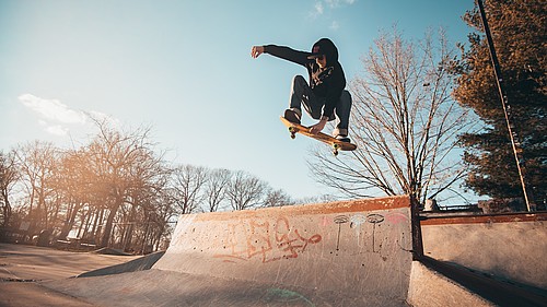 Ein Skater fliegt über eine Skaterparkrampe.