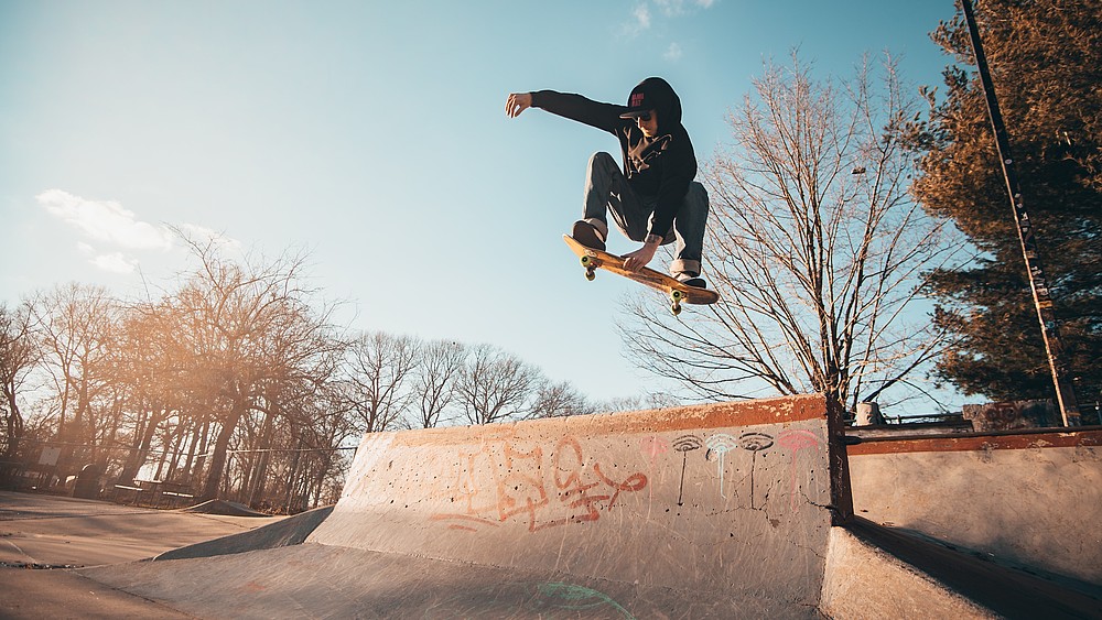 A skater flies over a skate park ramp.
