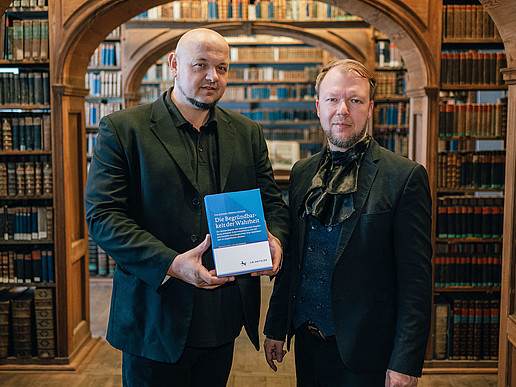 Prof. Matthias Schmidt and Tino Schmidt in a library.