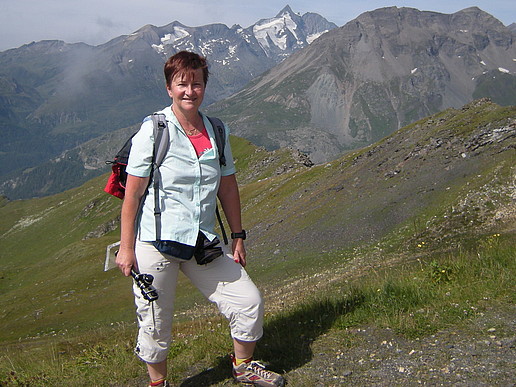 Prof. Spangenberg auf einer Wiese. Im Hintergrund sind hohe Berge zu sehen.