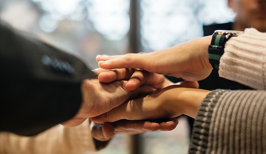 Five hands stacked on top of each other - Teamwork