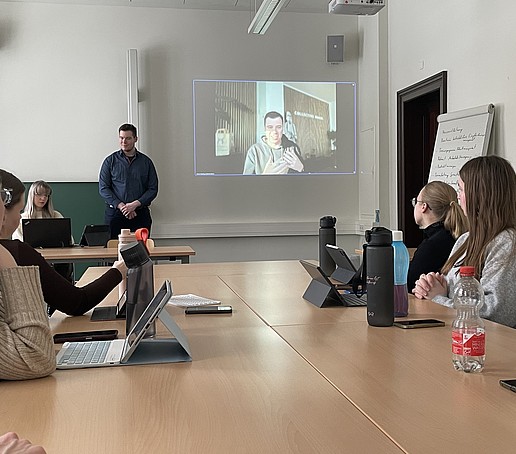 Students in the seminar room listen to a presentation.