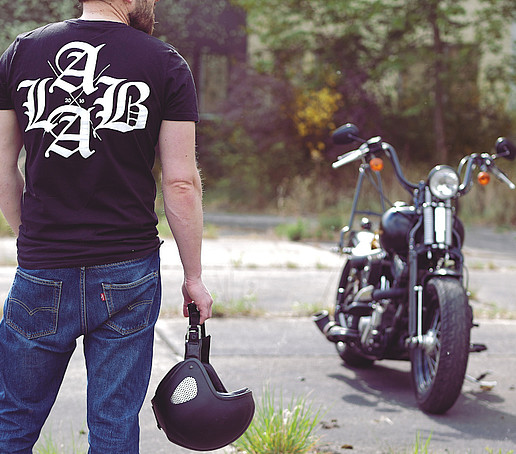 Photo of young man with labeled T-shirt and motorcycle