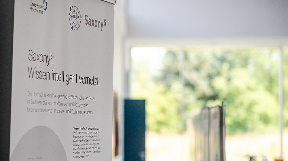 A Saxony5 roll-up stands in a hall with a view of the countryside.