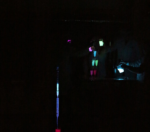 An experiment with colored liquids takes place in the dark.