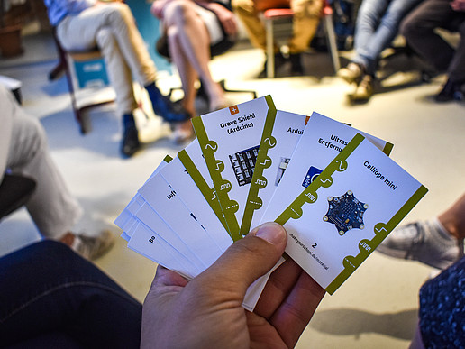 One hand holds several cards in a fan shape