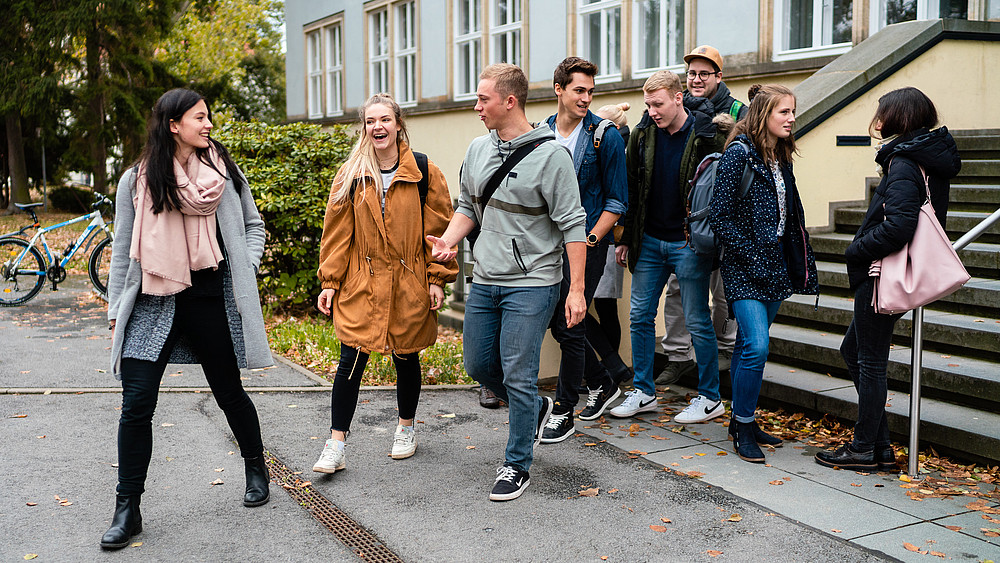 A group of cheerful students leaving a teaching building. Graduates with outstanding theses can hope to receive an award from the HSZG's sponsorship association.