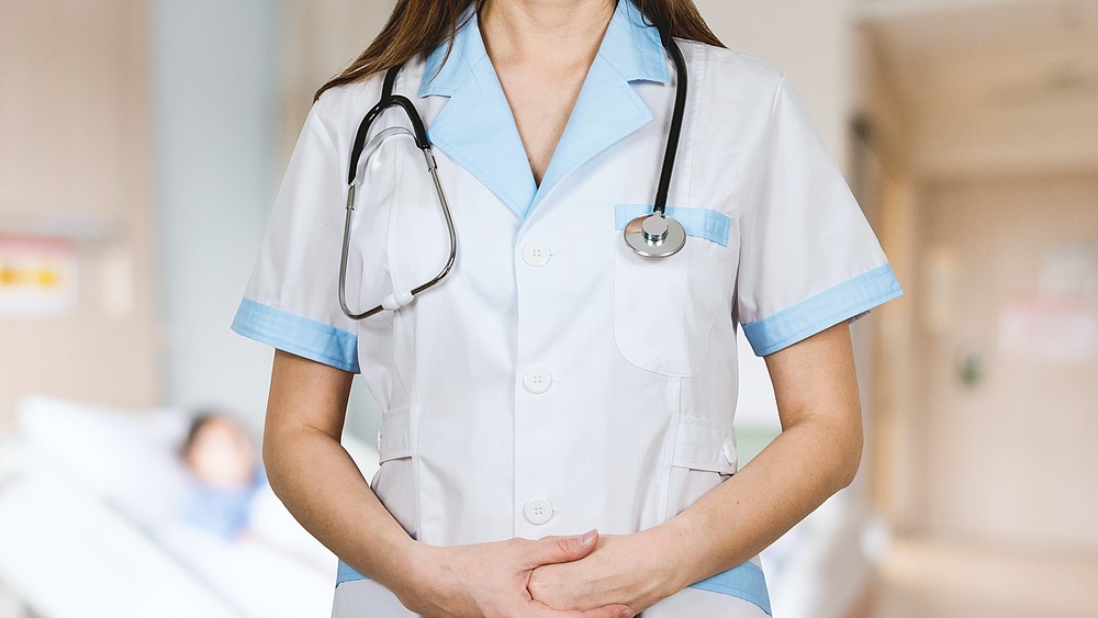 The upper body of a nurse with a stethoscope around her neck.