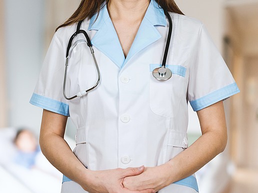 The upper body of a nurse with a stethoscope around her neck.
