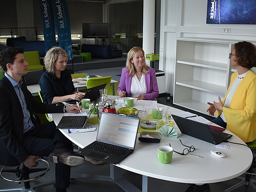 Vice-Rector Sophia Keil, her colleague and two ZEUSS representatives sit at a table in the DLR_School_Lab and discuss.