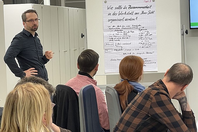 An employee explains something to the participants using a flipchart.