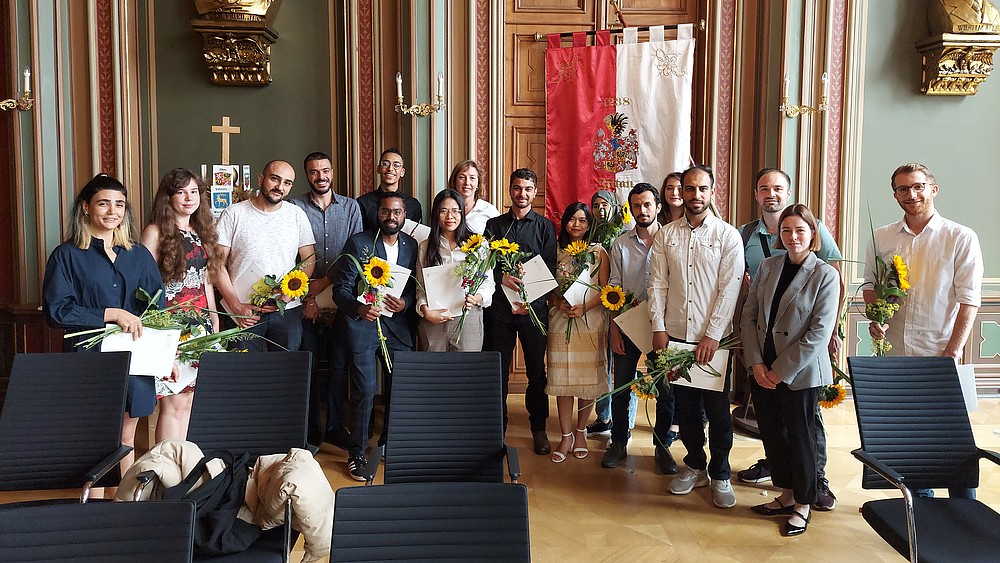 The graduates of the DSH course of the Studienkolleg stand in the Bürgersaal of the Zittau town hall to celebrate their degrees.