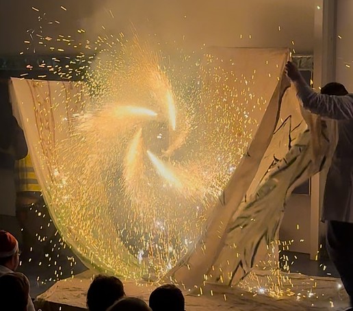A circular wheel of fire spins on the stage.