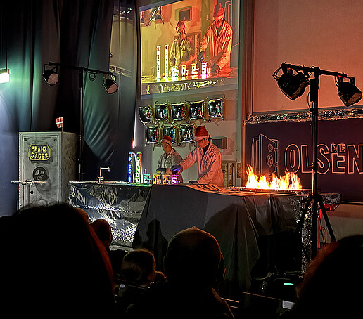 Two performers conduct a fire experiment.