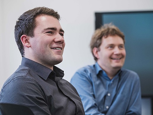 KIA student Richard sits smiling at a table in a conference room.