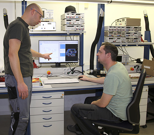 Der Ausbilder bespricht mit einem Auszubildenden den Bauplan am Computer.