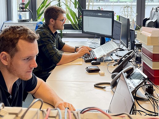Jan-Hendrik Smith and Karl Jacobie are sitting at their desks working on their computers.