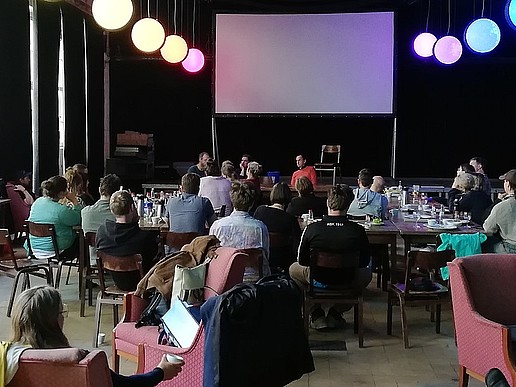 In einem Raum im Kulturhaus sitzen Alumni und HSZG-Mitarbeiter an Tischen und tauschen sich aus.