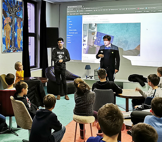 Kazimierz Przybysz and Daniel Winkler give a talk to a group of pupils.