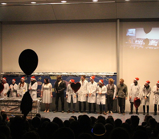 The entire team of the Chemistry Show Lecture is on stage wearing Christmas hats.