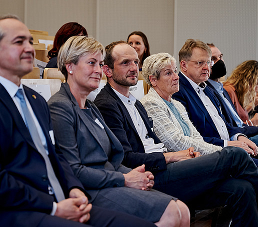 The audience in the lecture hall looks at the speaker.