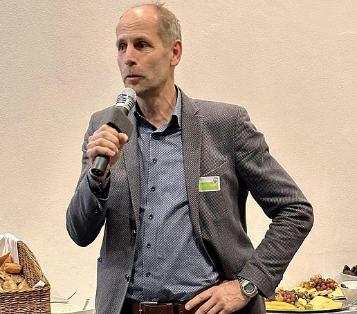 A researcher holds the microphone in his hand and delivers a pitch.