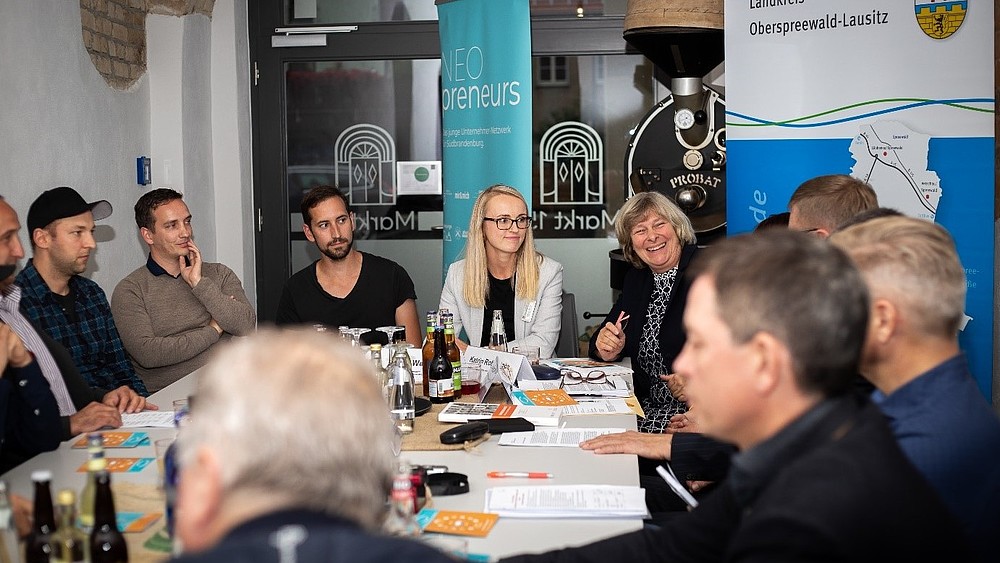 Participants in the preparations for the storytelling salon sit at the table and talk.