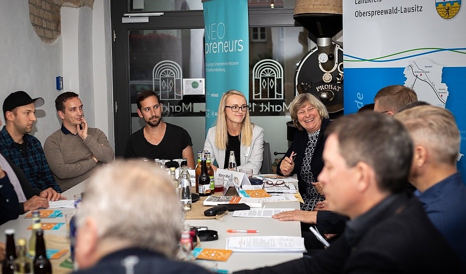 Foto: HSZG Teilnehmende an den Vorbereitungen des Erzählsalons sitzen am Tisch und untrhalten sich.