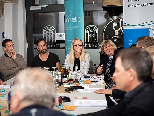 Participants in the preparations for the storytelling salon sit at the table and talk.