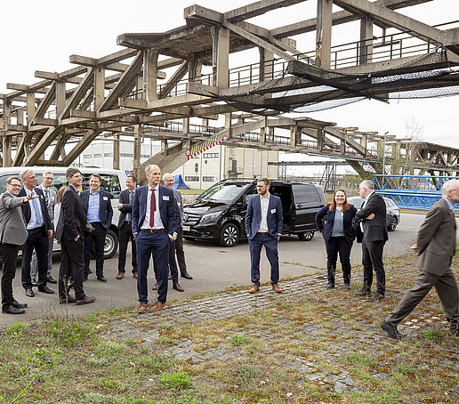 Teilnehmende im Industriepark Schwarze Pumpe versammeln sich zur Ortsbegehung im Freien.