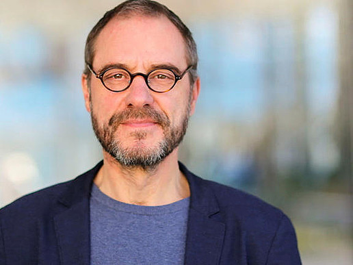 Prof. Kollmorgen with glasses and jacket smiles into the camera.