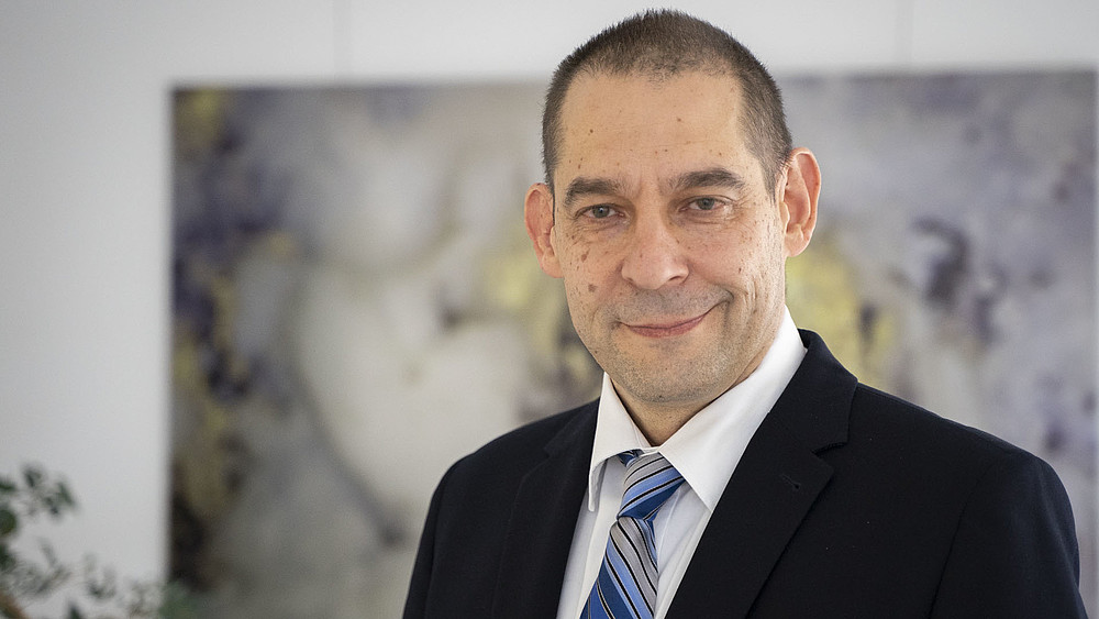 Dr. Stefan Zeller smiles into the camera.