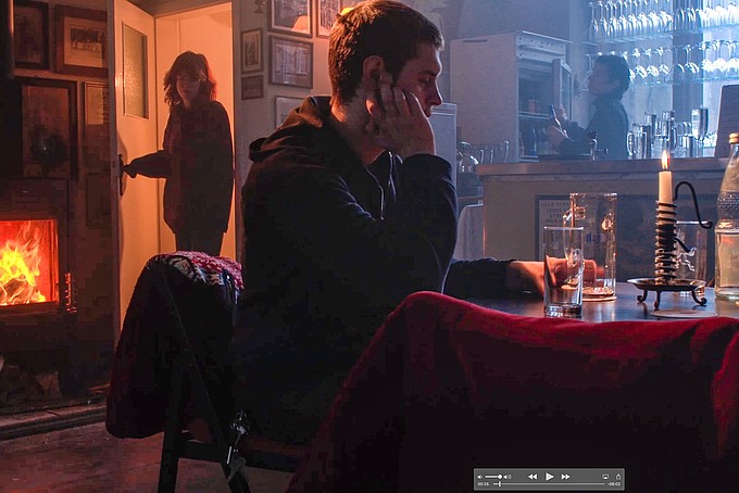 On a movie set, a course participant sits at a bar.