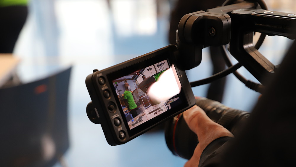 The display of a camera can be seen and a hand holding this camera for the video shoot for the 15Grad-Ostblog.