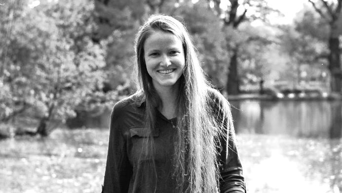 Stella Silbermann smiles as she walks along a jetty by a lake.