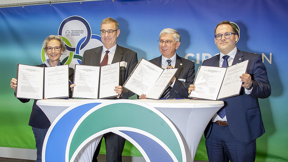 Prof. Ursula Staudinger, Rector of TU Dresden, Prof. Uwe Götze, Vice-Rector for Transfer and Continuing Education at TU Chemnitz, Prof. Klaus-Dieter Barbknecht, Rector of TU Bergakademie Freiberg and Prof. Alexander Kratzsch, Rector of Zittau/Görlitz University of Applied Sciences, hold up the signed cooperation agreements.