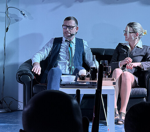 Two actors are sitting on the couch.