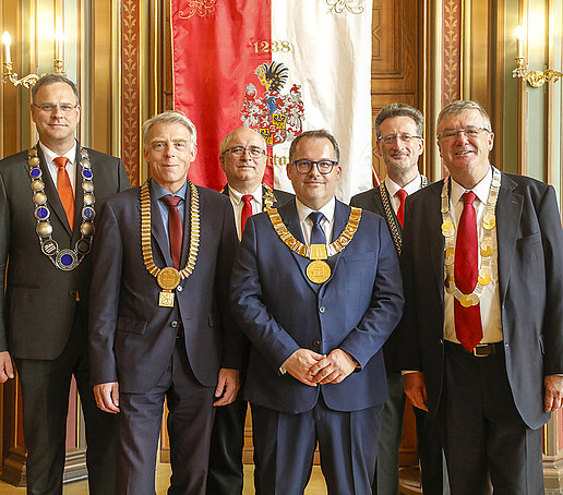 The rectors of the Saxon HAW stand next to each other in the Bürgersaal and smile into the camera.