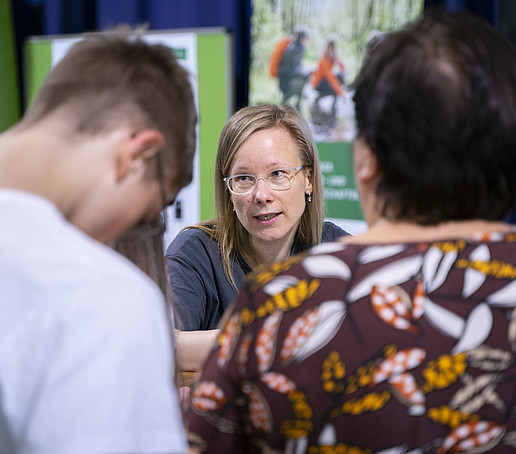 The student advisor in conversation with two visitors.