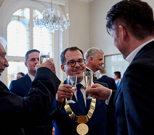 Bürgermeister und Rektor stoßen im Rathaus an.