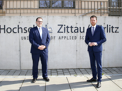 The Rector and Prime Minister stand in front of the HSZG sign in front of House Z I.